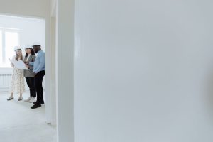 Tim Kontraktor dan Arsitek sedang berdiskusi di lokasi proyek renovasi rumah.