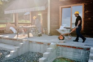 Tim Kontraktor Jawa Timur: Spesialis Bangun Rumah dan Renovasi sedang bekerja di lokasi proyek dengan latar belakang rumah modern.